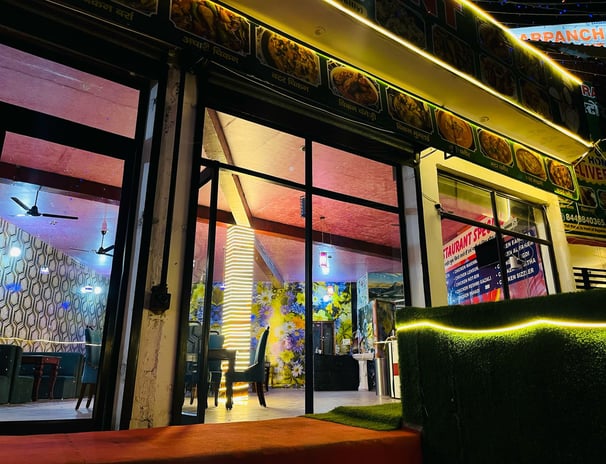 a restaurant with a large window and a green couch in Sarpanch Restaurant Bareilly Fatehganj