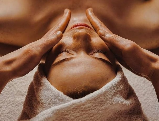 a woman getting a facial massage at a spa