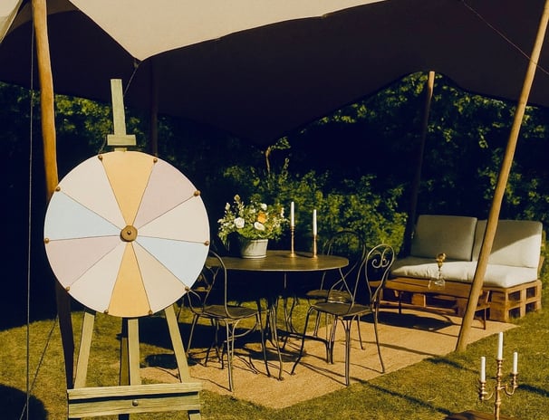 Roue de la chance vintage sous tente, coin jeu et salon en plein air décoré dans un style guinguette