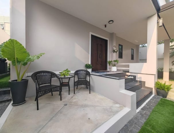 a patio with a table and chairs and a potted plant