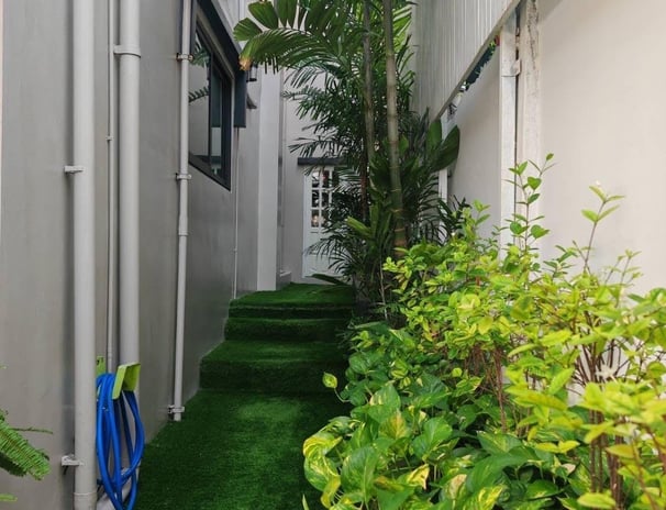 walkway with a green lawn and a hose leading to the beautiful home