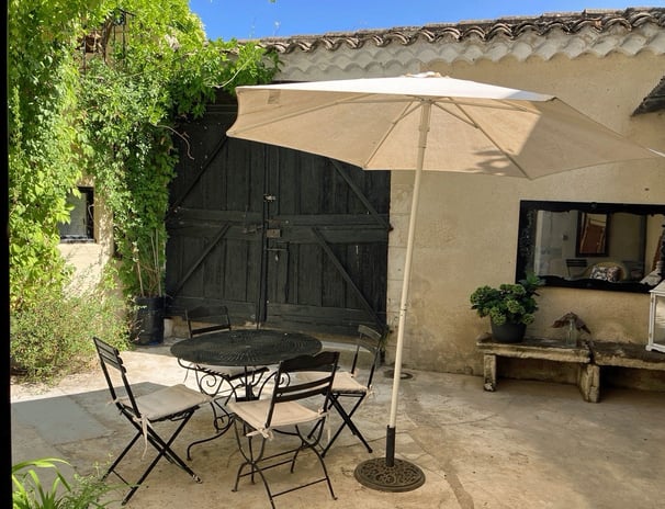 a patio table with chairs and umbrellas