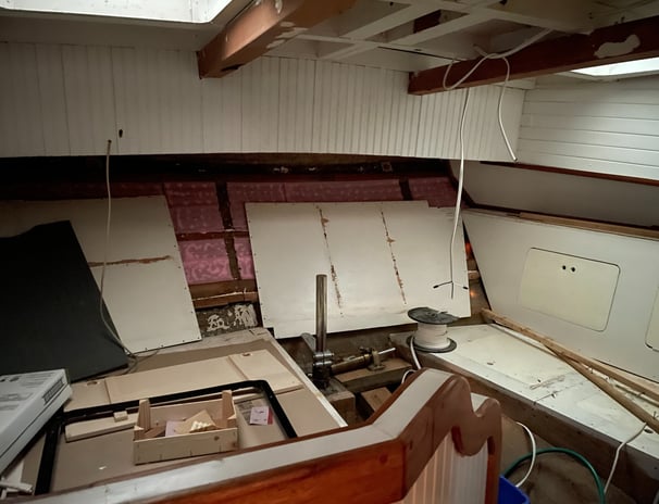 Aft state room with white panelling, the rudder post in the centre and storage on the side