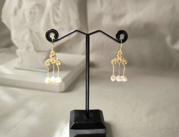 a pair of earrings with pearls and pearls
