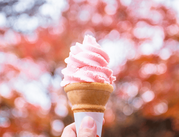 a person holding a cone with pink and white swirls