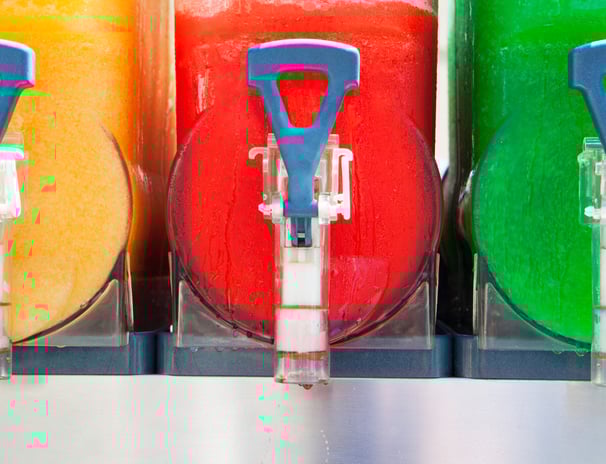 a bunch of different colored drinks in a row