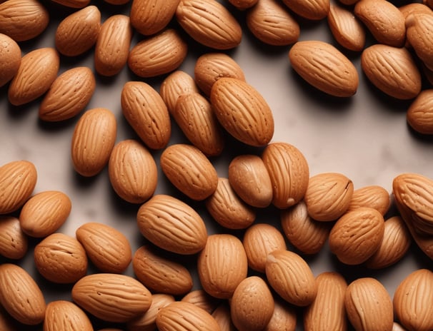 A close-up view of a pile of mixed nuts and seeds, including almonds, walnuts, and other unidentified varieties. The nuts have a natural, earthy texture and color, ranging from light beige to dark brown.