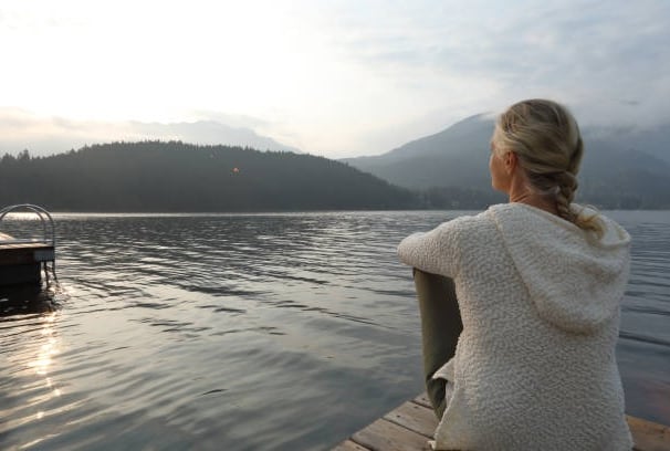 femme regardant l'horizon près d'un lac