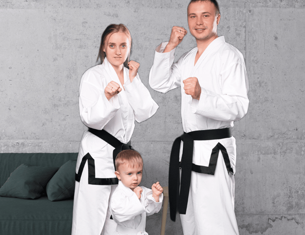 a man and woman in karate gear posing for a photo
