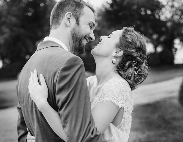 une mariée et un marié s'embrassant dans un champ