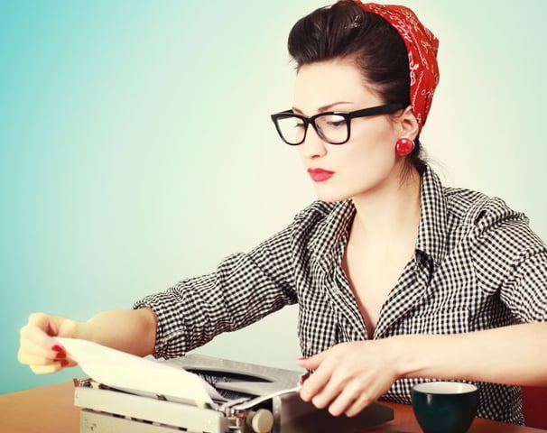 Woman wearing glasses reading a document like a detective.