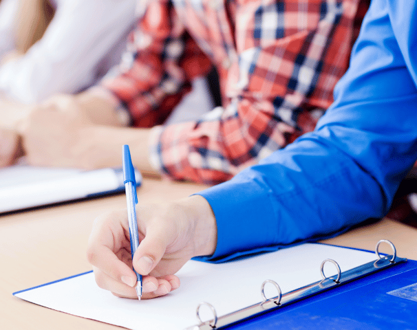 Student taking notes at a lecture.