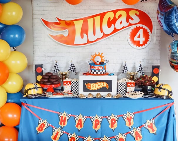 a birthday party table with a cake and balloons