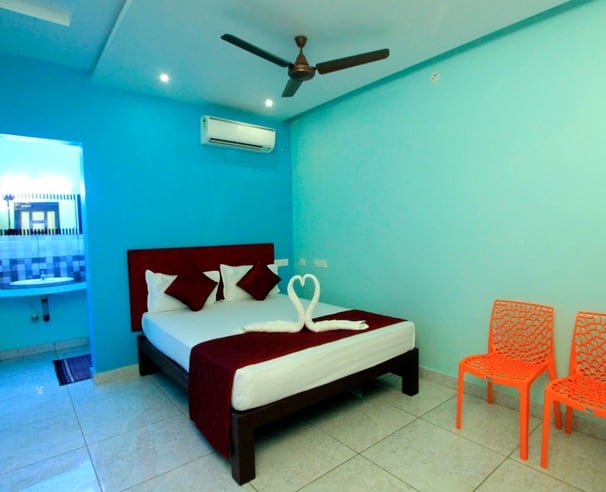 a bed room with a bed and two chairs