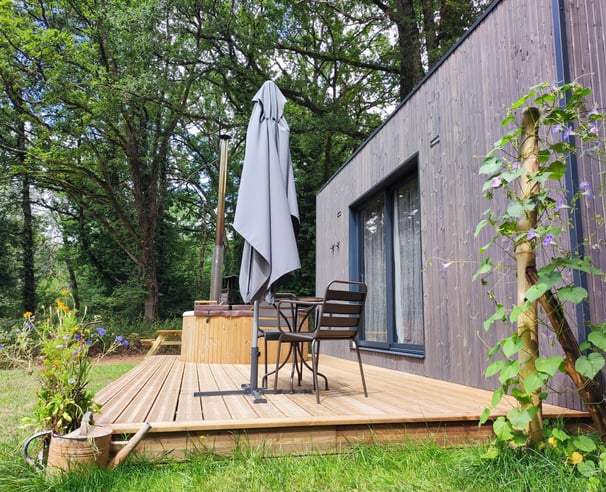 Cabane en bois naturel nichée dans un écrin de verdure