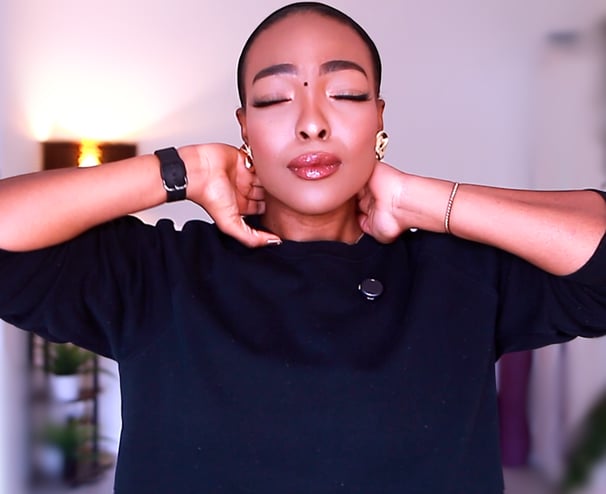 Joy Ogude - a woman physio with her eyes closed and her hands on her painful neck