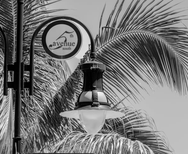 a light pole and street sign saying 5th eve s, in downtown naples florida