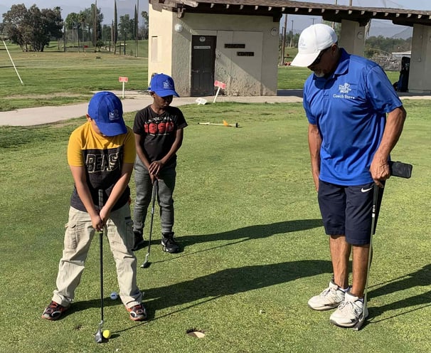 Enhancing Forward Action image of golf instructor teaching young students how to put