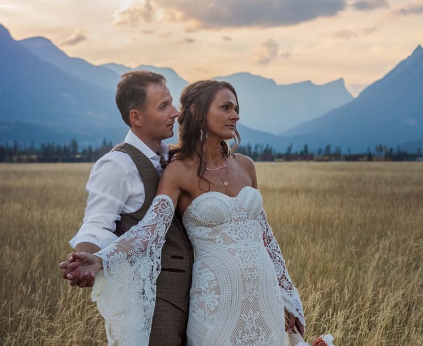 a bride and groom standing in a field in Yoho provincial park