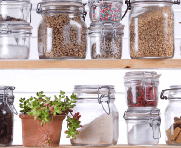 Rows of mason jars with food in them on a shelf.