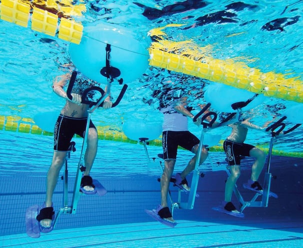 uomini che svolgono esercizi con cyclette in piscina