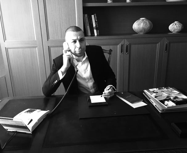 a man in a suit and tie is talking on the phone