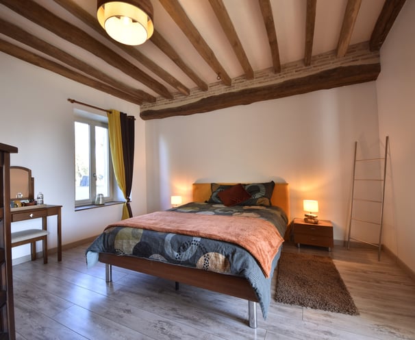 chambre lit double, poutres apparentes et briques