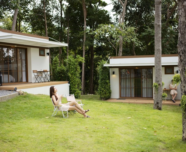 a woman sitting in a lawn chair in a front-yard green carpeted (grass) lawn, of The Boulder Phangan