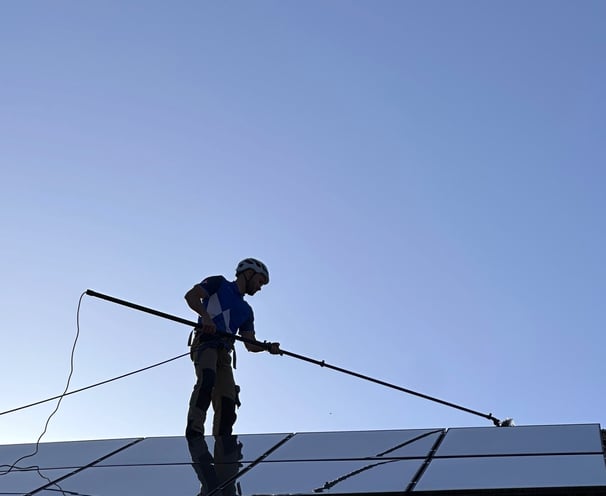 a man on a roof top with a pole pole