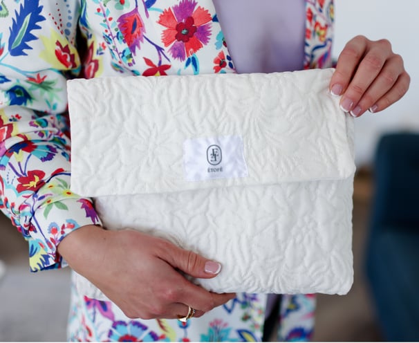 Pochette à rabat blanche ÉTOFÉ en tissu recyclé texturé, faite main en France, tenue par une femme