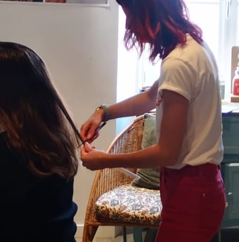 a woman is cutting a woman's hair