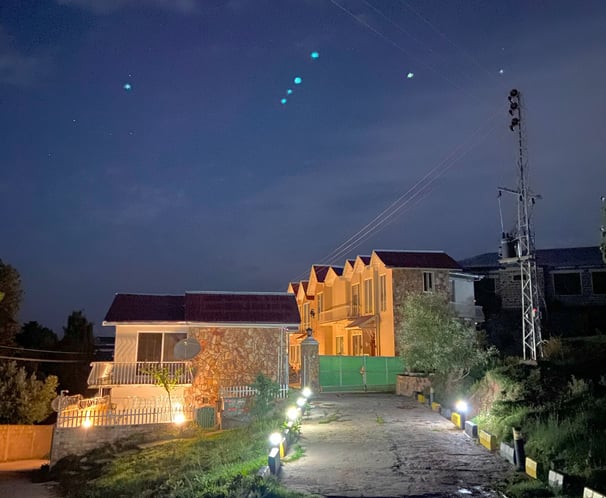 a street light shines brightly on the entrance of swiss cottages in the night sky