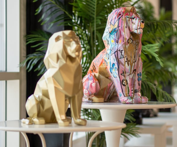 two statues of two lions sitting on a table