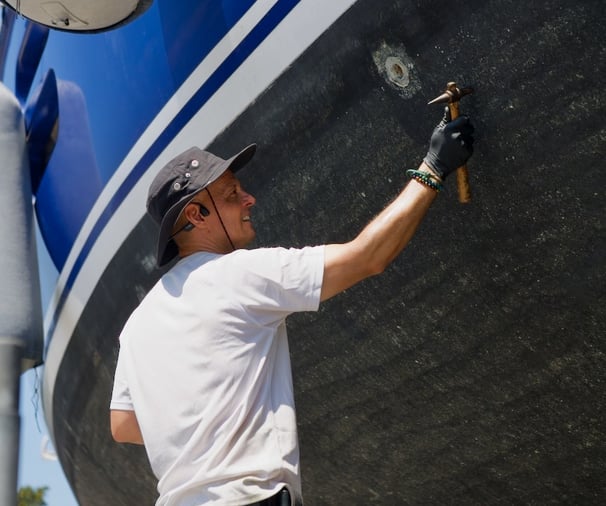 our marine surveyor taking ulytrasonic measurements in a aluminium yacht