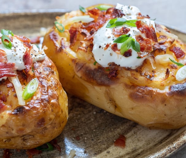 Golden-brown potato skins filled with creamy whipped potatoes, topped with melted cheese and crispy 