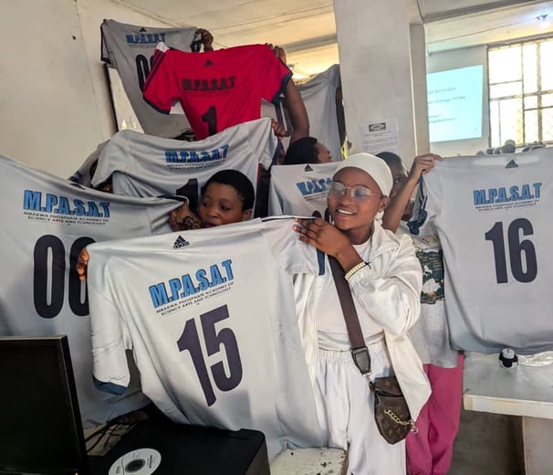 girls holding white jerseys with numbers on