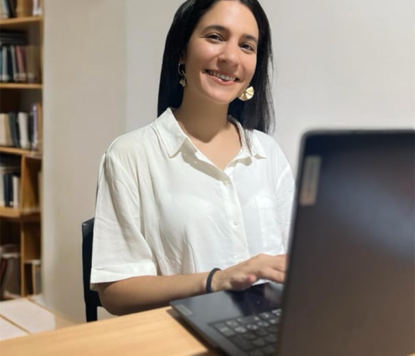 a woman sitting at a table with a laptop