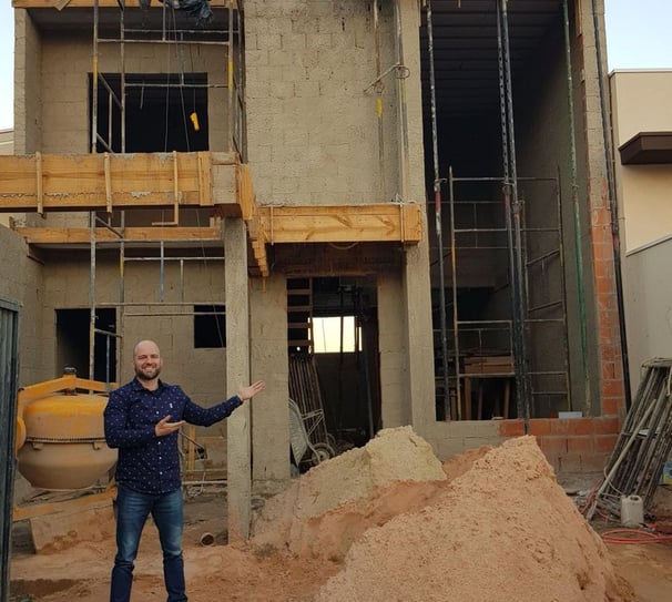 Engenheiro em frente a construção civil explicando projeto técnico