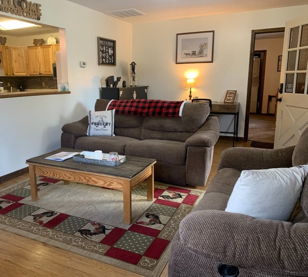 Cozy living room with a two reclining couches, coffee table and a Roku Smart TV. 