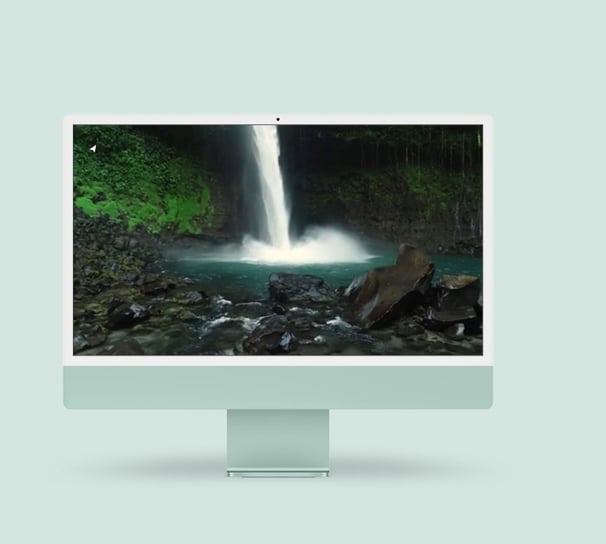 a desktop computer monitor with a waterfall in the background