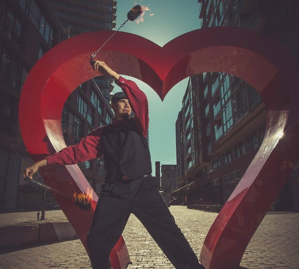 Fire poi dancer in front of heart