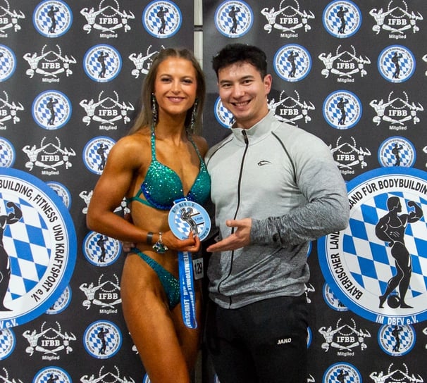 eine bikini wettkampfathletin mit ihrer neu gewonnen medaille auf der bayrischen meisterschaft