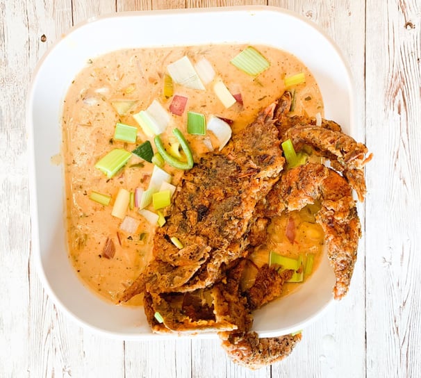 a bowl of soup with a fried crab