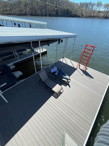 a man sitting on a dock with a chair and a ladder