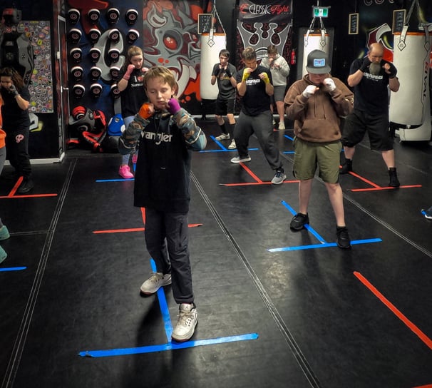 a group of beginner boxers lined up, shadow boxing