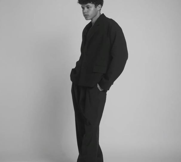 a man in a suit and tie is standing in a studio