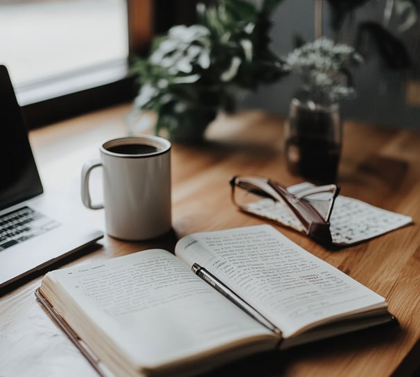 Open Bible and coffee cup on a table – faith and reflection in Christian leadership
