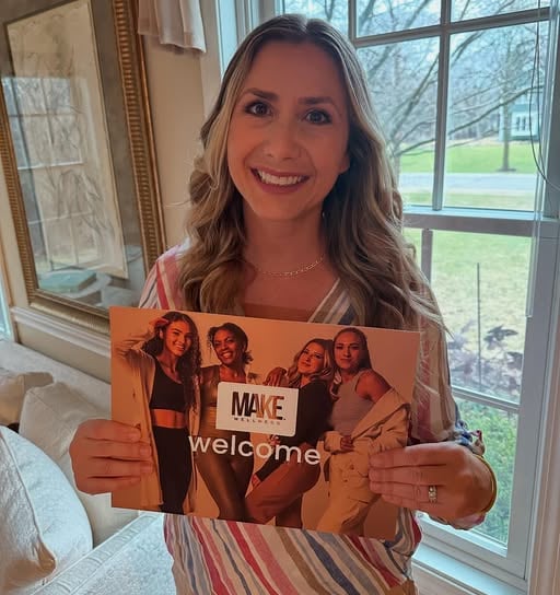 Woman posing with Make Wellness product literature. Welcome.