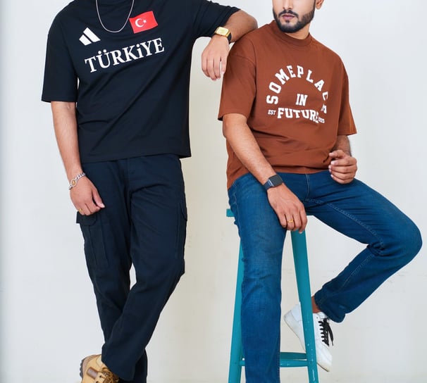 two men sitting on a stool in a room