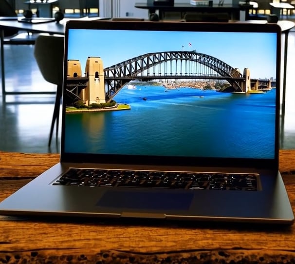 A laptop open on a rustic table the Sydney Harbour Bridge is on the screen